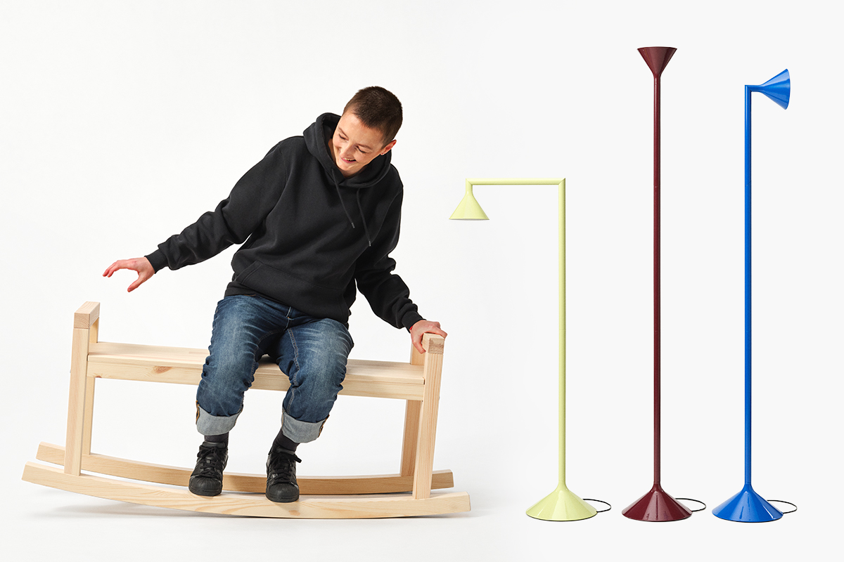 A person sits on a wooden rocking bench next to a trio of adjustable lamps.